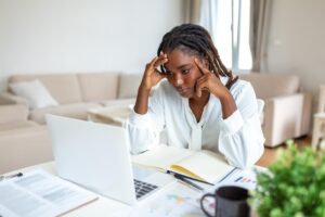 serious frowning african american ethnicity woman sit workplace desk looks laptop screen read email feels concerned bored unmotivated tired employee problems difficulties with app 1212 12800