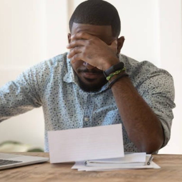 Stressed upset african american reading bad news in letter, confused about bank debt notification or banking loan rejection, money problem document, high taxes in bills, concerned about utility bill.