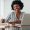 Portrait of a smiling woman sitting at table with laptop and dairy. Woman smiling at camera while working from home office.