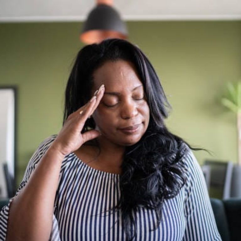 Mature woman with headache at home