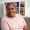 Obese African-American mature lady with short hair looks straight and smile closeup