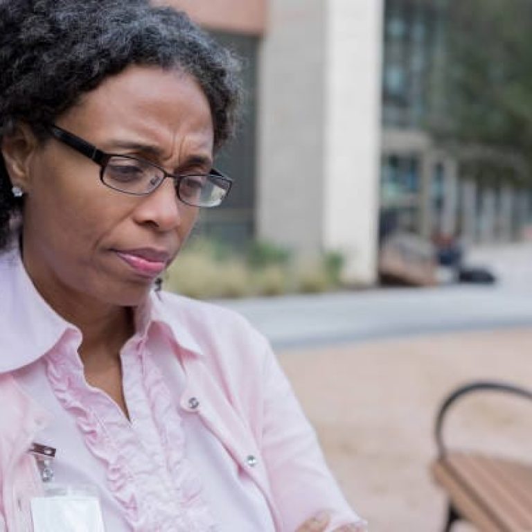 As she waits for her ride, a business professional is worried about being laid off.