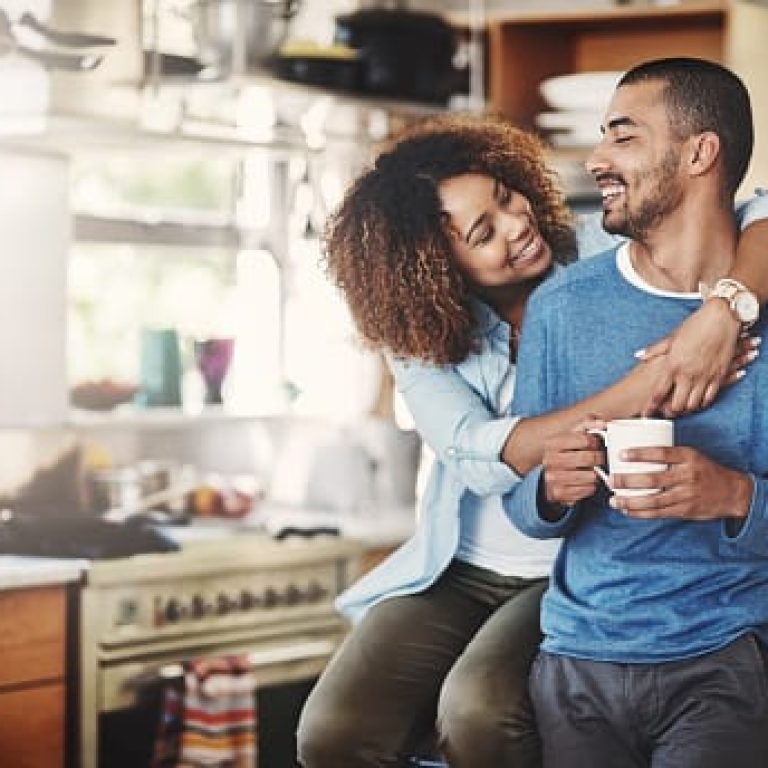 Shot of a happy young couple relaxing in the kitchen in the at home