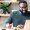 Cheerful African-American male student or worker in glasses is watching online lectures or webinars and writing notes in a notebook