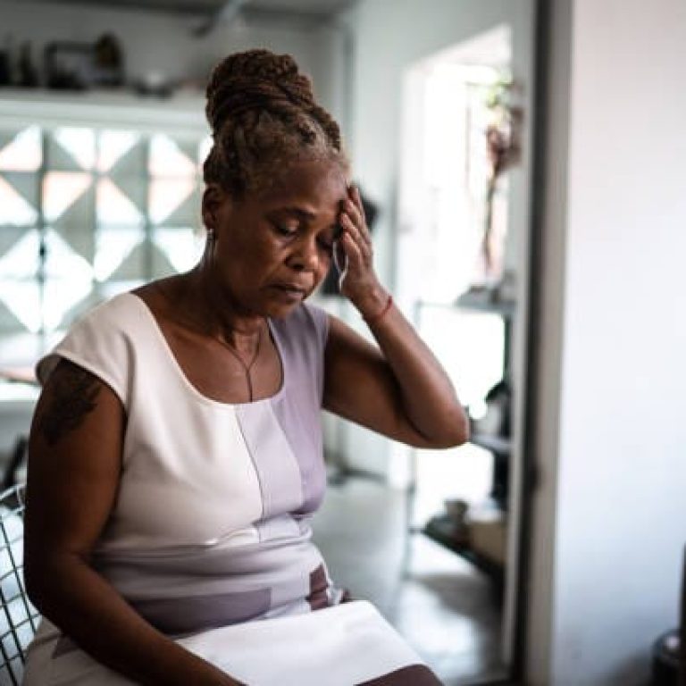 Mature woman with headache at home