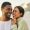 Fun, free and happy couple laughing and hugging at the beach, enjoying fresh air and time together. Young lovers talking and bonding while being affectionate, sharing a funny joke while walking