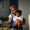 Woman carrying baby son (6-11 months) and talking on mobile phone in kitchen