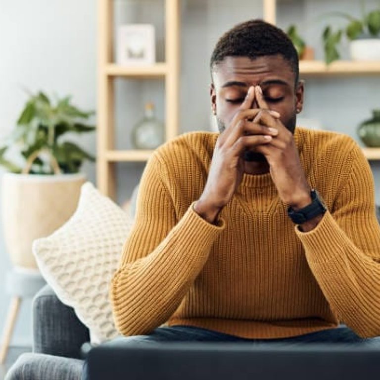 Shot of a young man looking stressed out at home