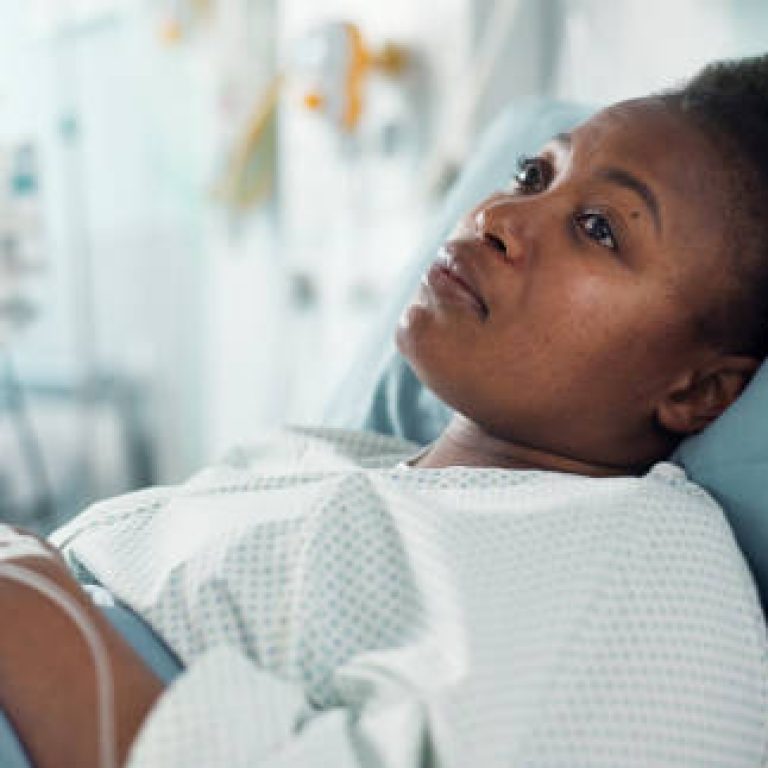 Sad, sick and a thinking black woman in a hospital bed for healthcare, exam and a surgery. Tired, depression and an African clinic patient in a ward for treatment help, mental health or a virus